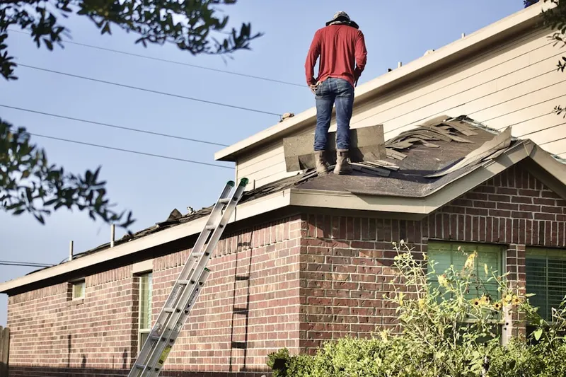 Professional roofer working on a residential roof in Breezewood Farms